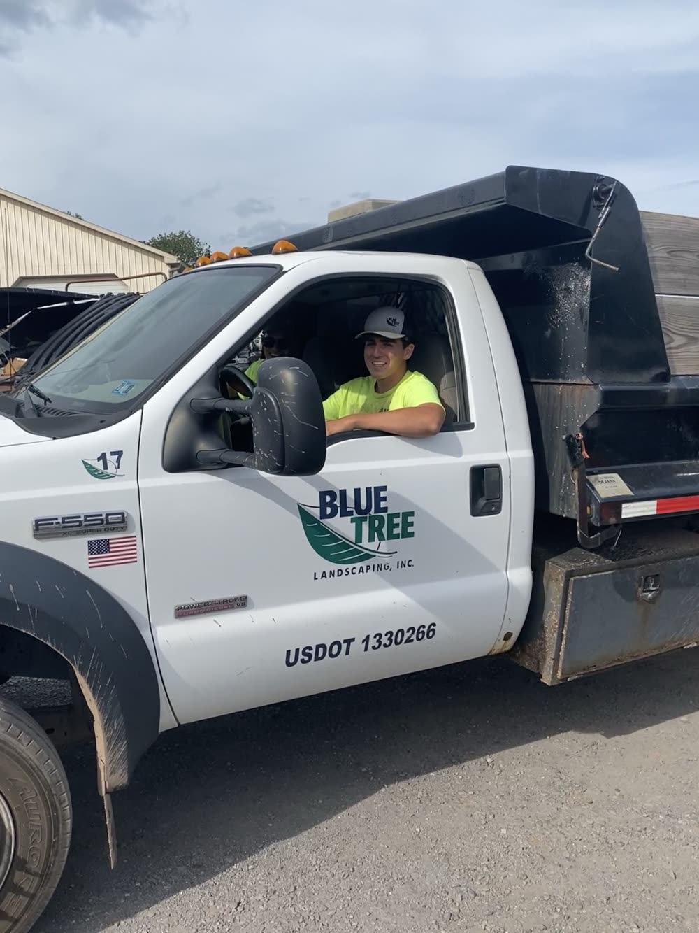 Blue Tree branded landscaping truck and crew at a job site.
